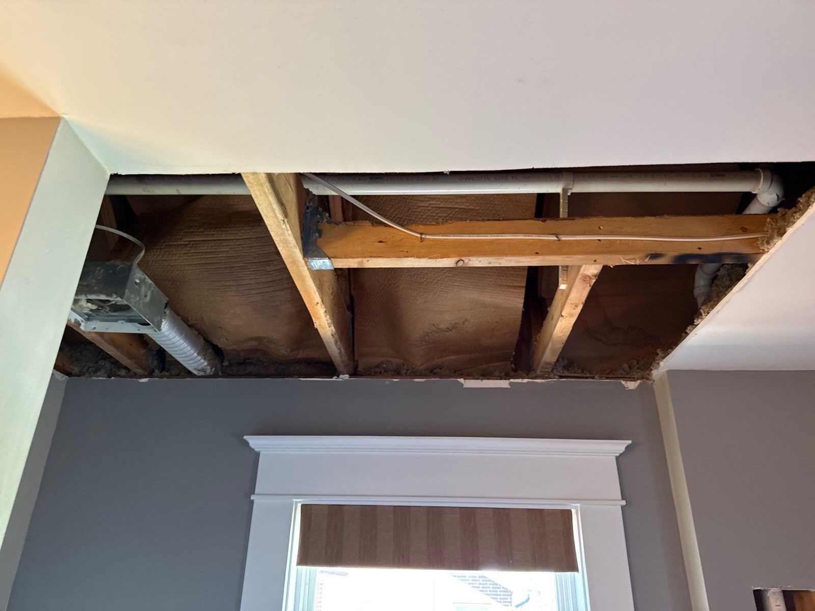 A water-damaged bathroom ceiling removed down to the joists