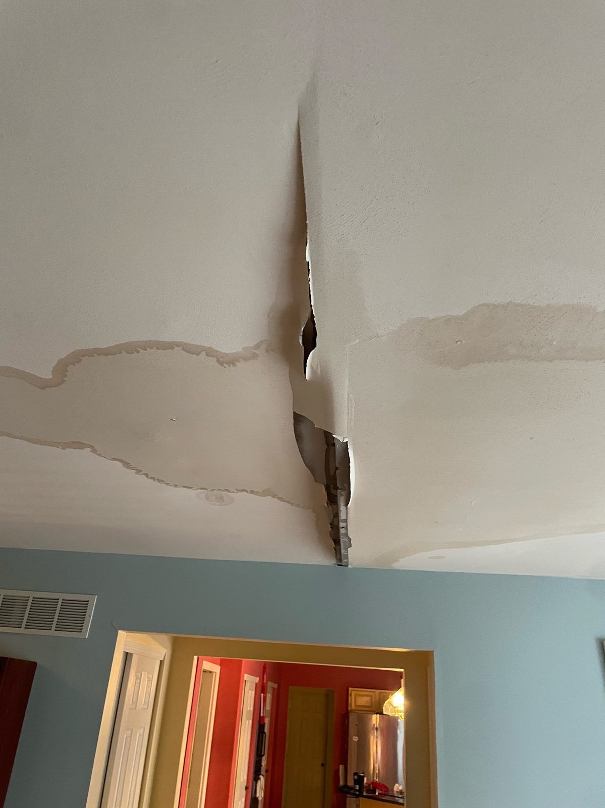 A water-damaged ceiling starting to sag and crack